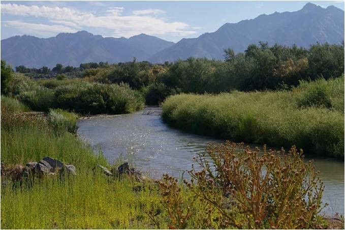 slow moving Jordan river with mountain peaks in the background